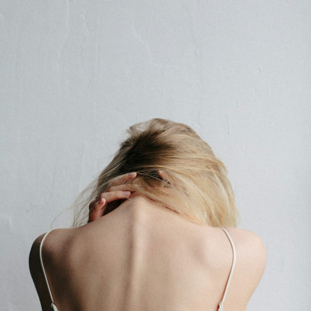 Woman rubbing the back of her upper neck